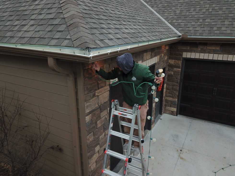 man hanging holiday lights