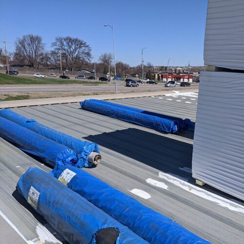 rolls of roofing membrane laying on a roof