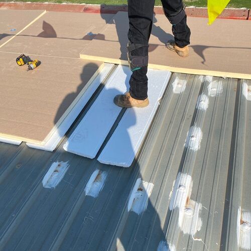 worker standing on a metal roof